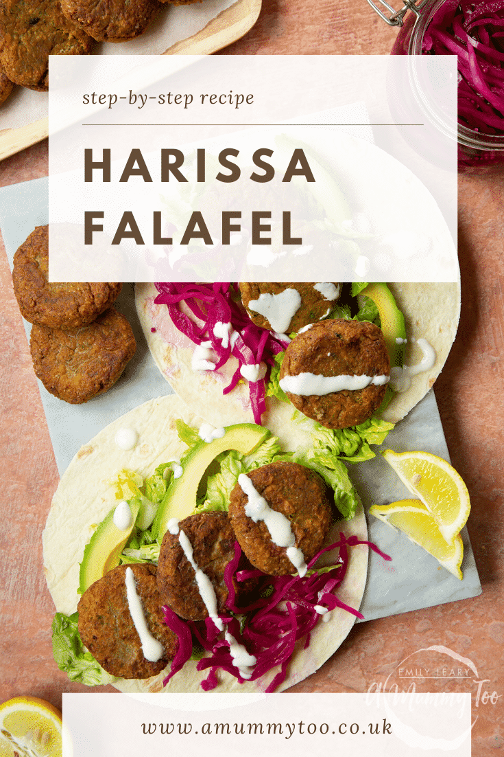 Two harissa falafel wraps arranged on a marble board with pickled cabbage and salad, drizzled with tahini dressing. The text caption reads, harissa falafel.