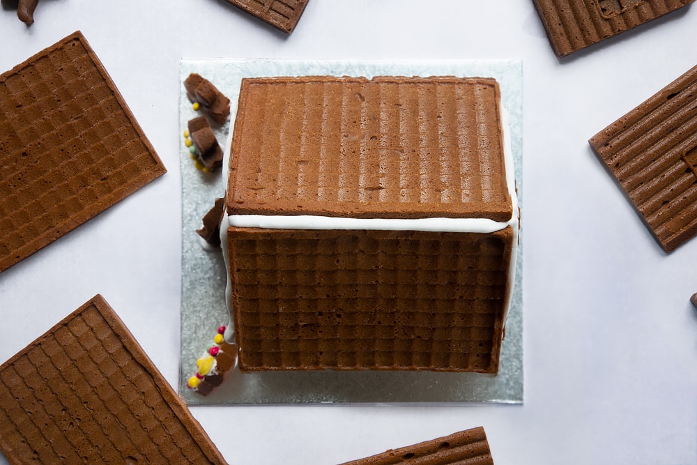 A gingerbread house on a silver board.