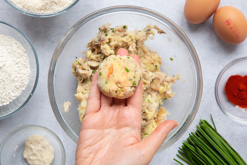 Flattening the mackerel fishcake balls a little with your hand. 