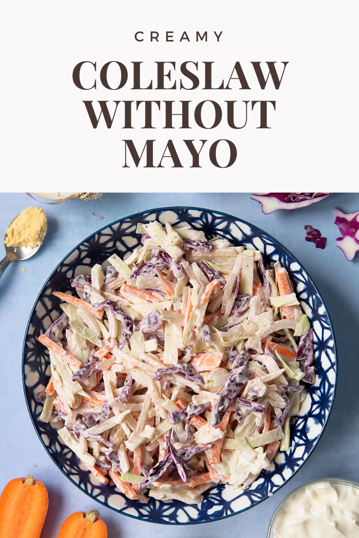 Creamy coleslaw without mayo served in a bowl. The bowl is surrounded by vegetables and creme fraiche. Caption reads: creamy coleslaw without mayo.