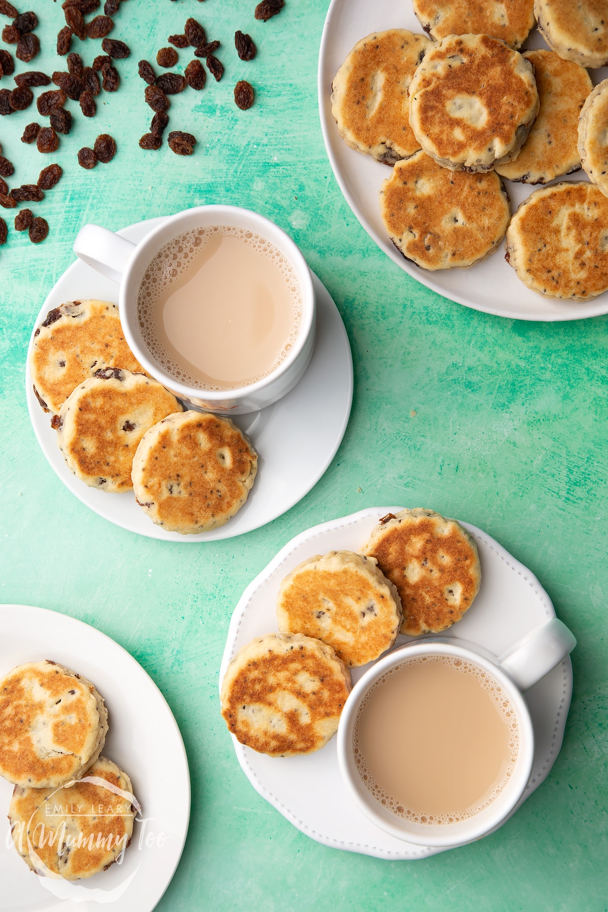 Vegan Welsh cakes arranged on a white plates with cups of tea.