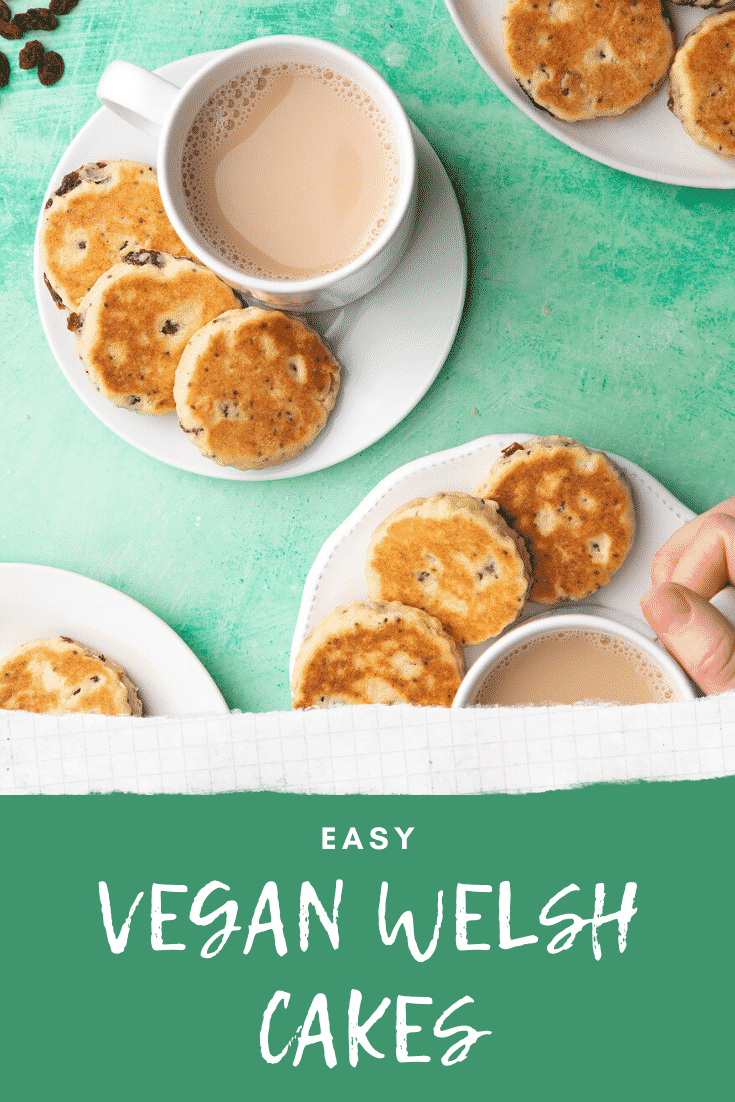 Vegan Welsh cakes arranged on small white plates with cups of tea. Caption reads: Easy vegan Welsh cakes.