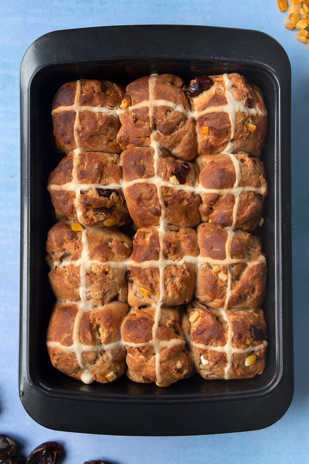 Freshly baked vegan hot cross buns in a baking tray. 